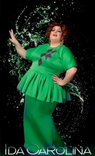 Ida Carolina in a green and purple dress against a water spray background.